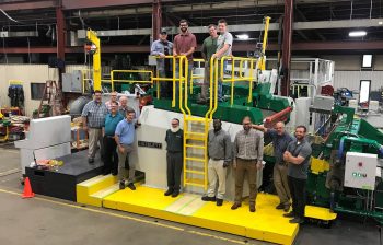 JW Aluminum and Hazelett employees standing with the new AS2000 twin-belt casting machine to be delivered to JW.