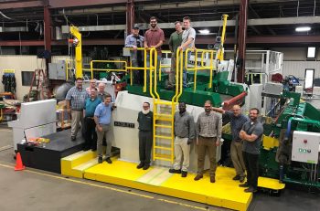 JW Aluminum and Hazelett employees standing with the new AS2000 twin-belt casting machine to be delivered to JW.