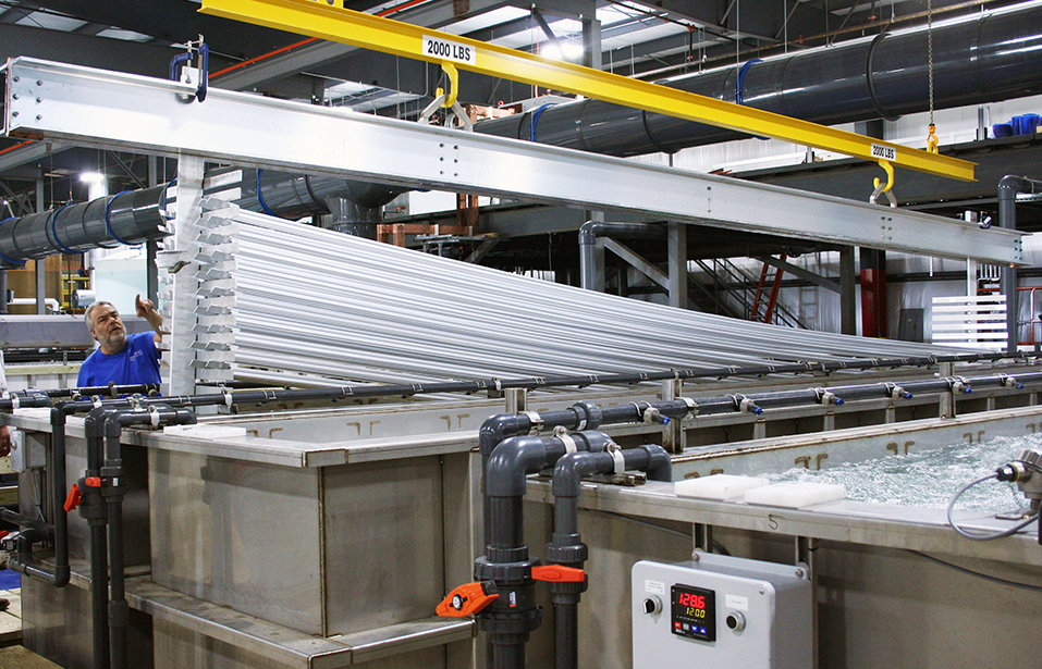 Figure 1. Long aluminum profiles being removed from a processing tank in NIA’s new line.