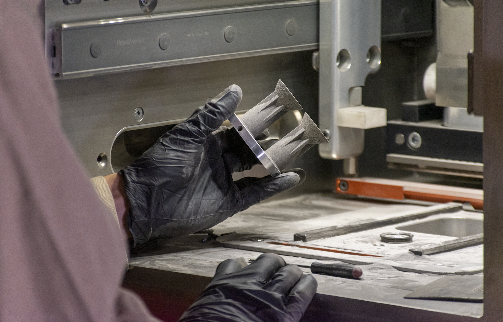 Additive manufacturing with 7A77.60L aluminum alloy: An HRL scientist completes visual inspection of 3D-printed micro-thrusters after build completion .