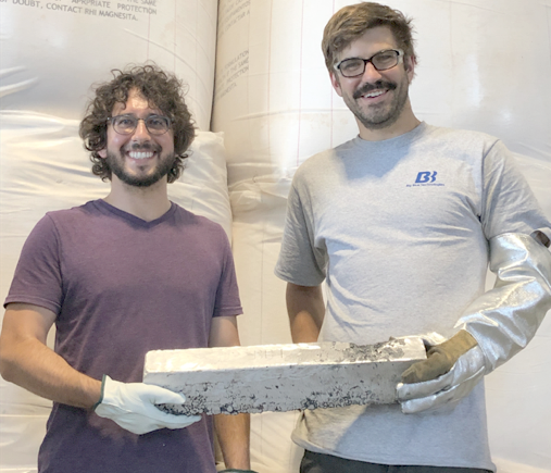 Figure 1. Boris Chubukov (right) and Aaron Palumbo (left), cofounders of Big Blue Technologies, hold the first magnesium ingot generated using the company’s proprietary vacuum carbothermal reduction process.