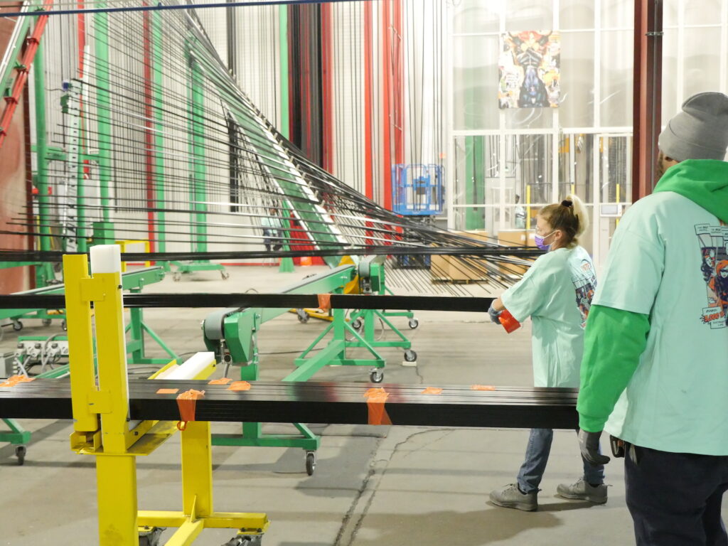 Figure 3. Personnel at the Garden City plant monitor the coated extrusions as they come off the new CUBE vertical powder coating line.
