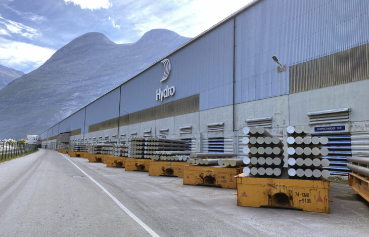 Exterior of Hydro's Sunndal plant, showing aluminum billet stacked in front