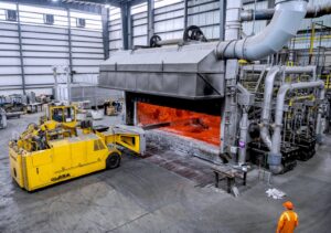 Figure 2. A semi-automatic machine skims the surface of the melting furnace.