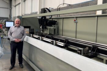 Kenny King, production manager for Tradeglaze, stands next to the new Phantomatic X4 CNC machining center.