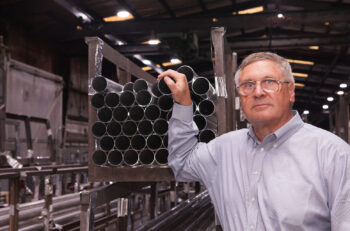 Steve James, managing director at Alfiniti, stands in front of 6061-T8 tubes.