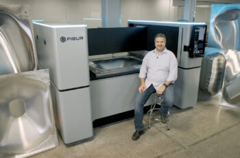 Justin Nardone, CEO of Figur, a Desktop Metal brand, sits in front of the digital digital sheet forming (DSF) technology. (Photo: Business Wire.)