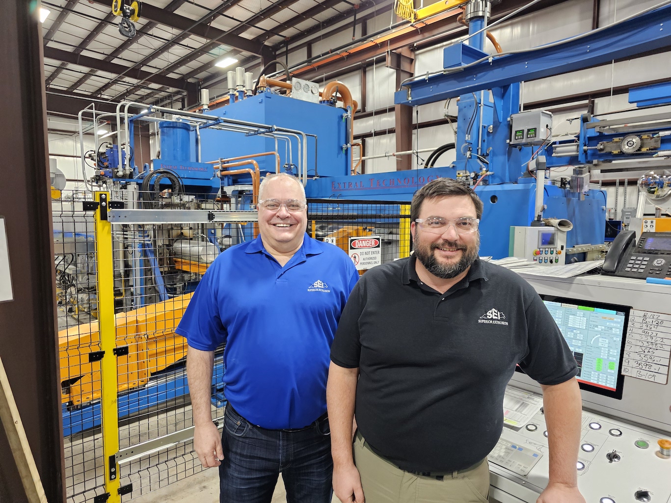 Figure 1. George LaBlonde, president and chairman of the board (left), and Matt DeBolt, chief operating officer, stand in front of the new extrusion press.