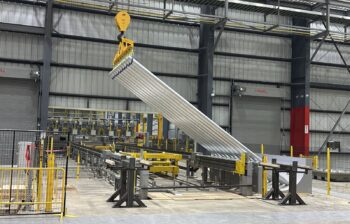 Aluminum billet made from recycled scrap being lowered onto a table at Cassopolis.