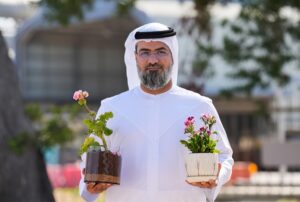 Figure 3. Abdalla Alzarooni, EGA, holds plants grown in Turba, a manufactured soil produced using optimized bauxite residue. (Source: EGA.)