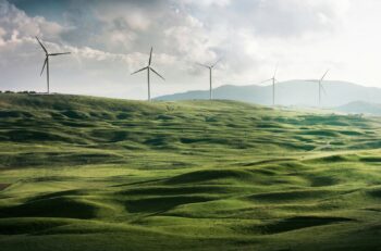 wind mills on the horizon over a green field
