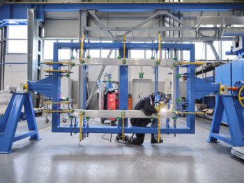 a man welds an aluminum frame for a train car