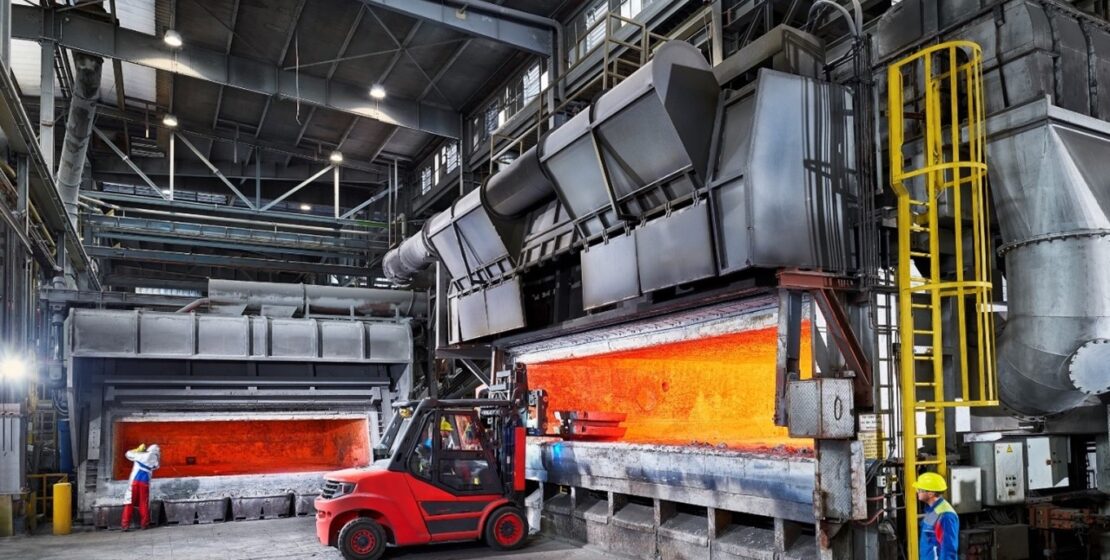 aluminum melting furnaces with the doors open, showing the orange glow of the flames