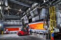 aluminum melting furnaces with the doors open, showing the orange glow of the flames