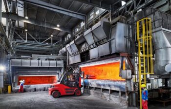 aluminum melting furnaces with the doors open, showing the orange glow of the flames