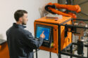 A man stands in front of a computer screen for monitoring molten metal analysis