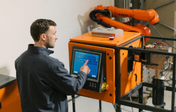 A man stands in front of a computer screen for monitoring molten metal analysis