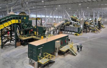 Two men appear tiny in an arial view of this scrap sorting equipment.