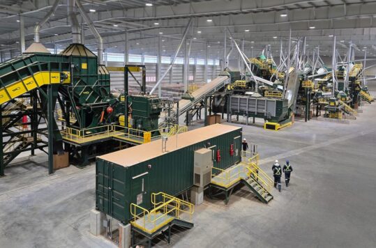 Two men appear tiny in an arial view of this scrap sorting equipment.