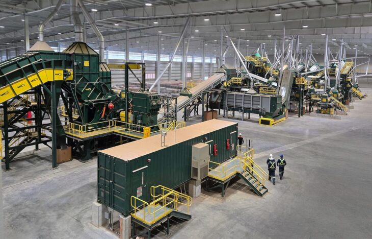 Two men appear tiny in an arial view of this scrap sorting equipment.