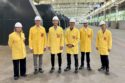 Men standing in an industrial plant.