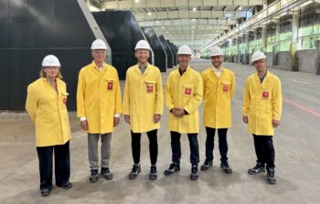 Men standing in an industrial plant.