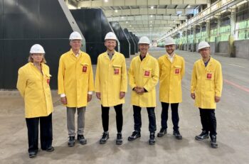 Men standing in an industrial plant.