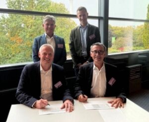 Four man in suits pose for the photo.