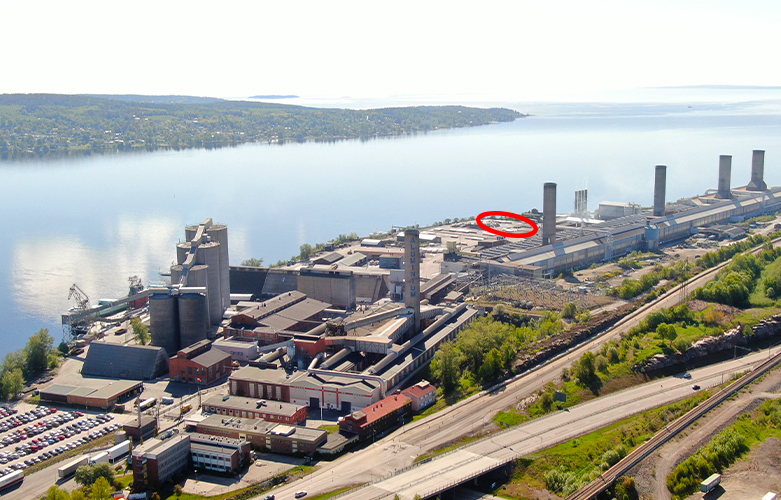 Aerial view of an industrial plant. A red circle indicates the placement of a new recycling area.