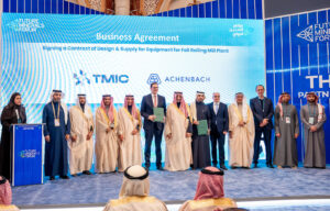A group of people in suits and middle easter dress stand on stage for an announcement ceremony