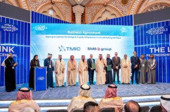 A group of people in suits and middle easter dress stand on stage for an announcement ceremony