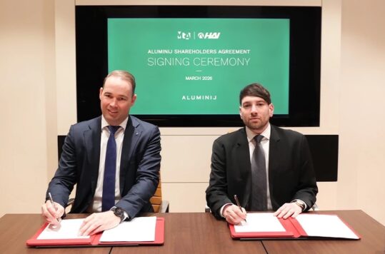 Two men in suits at a signing ceremony