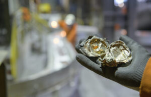 A hand holds up crushed aluminum cans