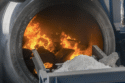 Rotary recycling furnace showing the flames melting aluminum scrap.
