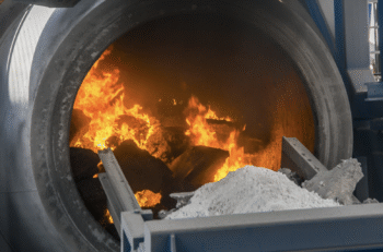 Rotary recycling furnace showing the flames melting aluminum scrap.