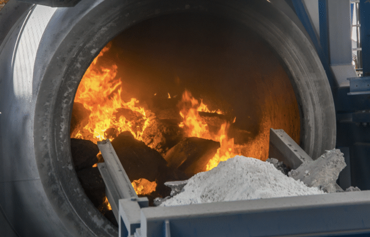 Rotary recycling furnace showing the flames melting aluminum scrap.