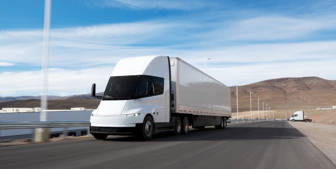A large semi truck on a lonely desert road.
