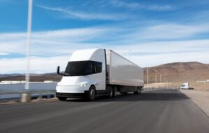 A large semi truck on a lonely desert road.