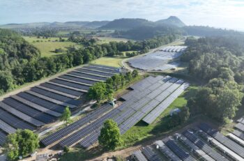 Aerial view of a solarpark in green fields.