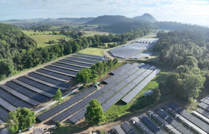 Aerial view of a solarpark in green fields.