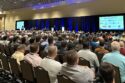 A roomful of people watching a presentation