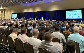 A roomful of people watching a presentation