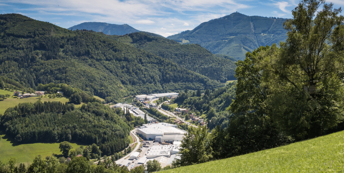 Aerial view of an industrial plant amid green fields.