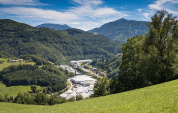 Aerial view of an industrial plant amid green fields.